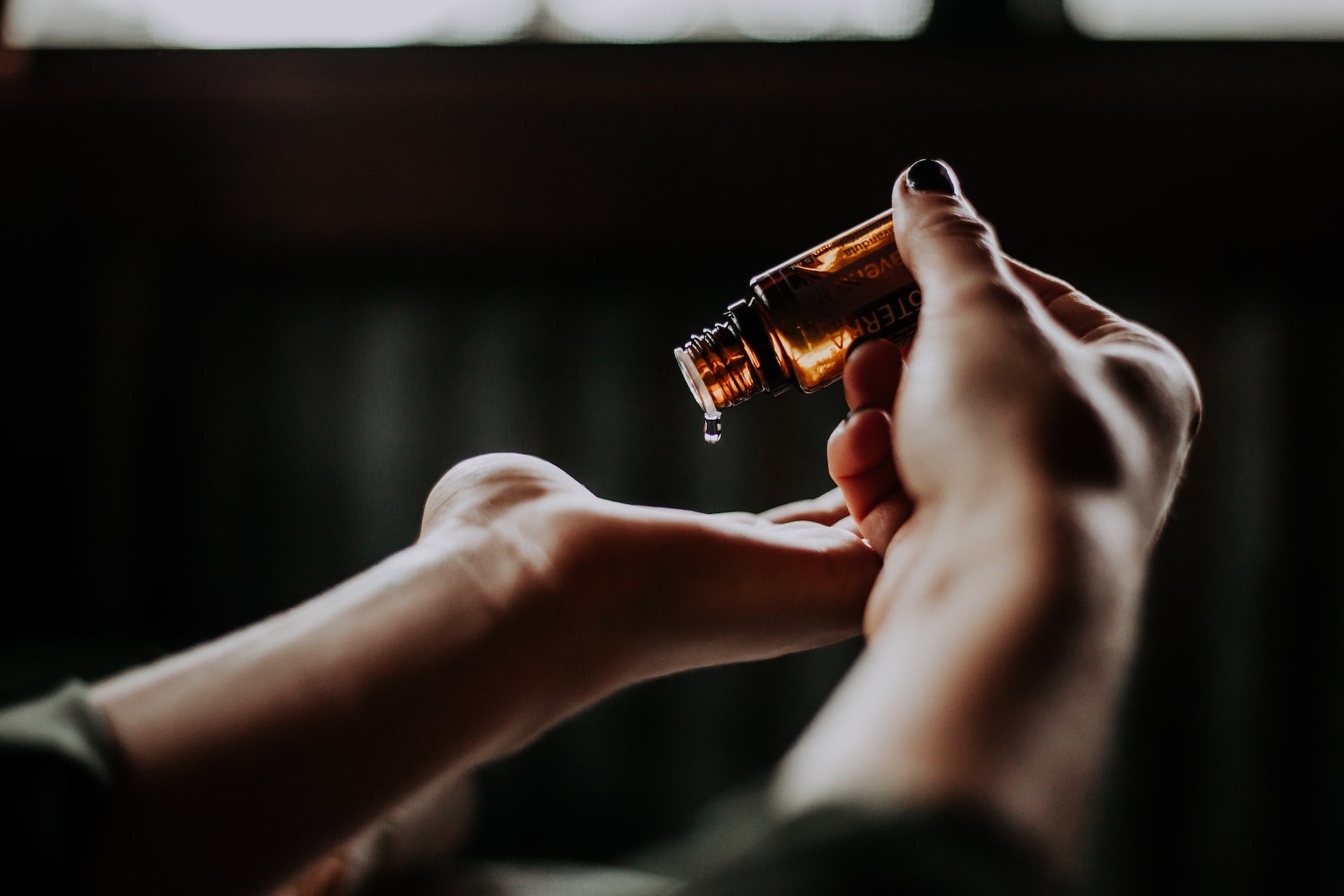 Person applying hair oil onto hand